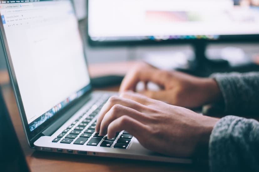 Personne tapant sur un ordinateur portable pour gérer un contenu web via un CMS