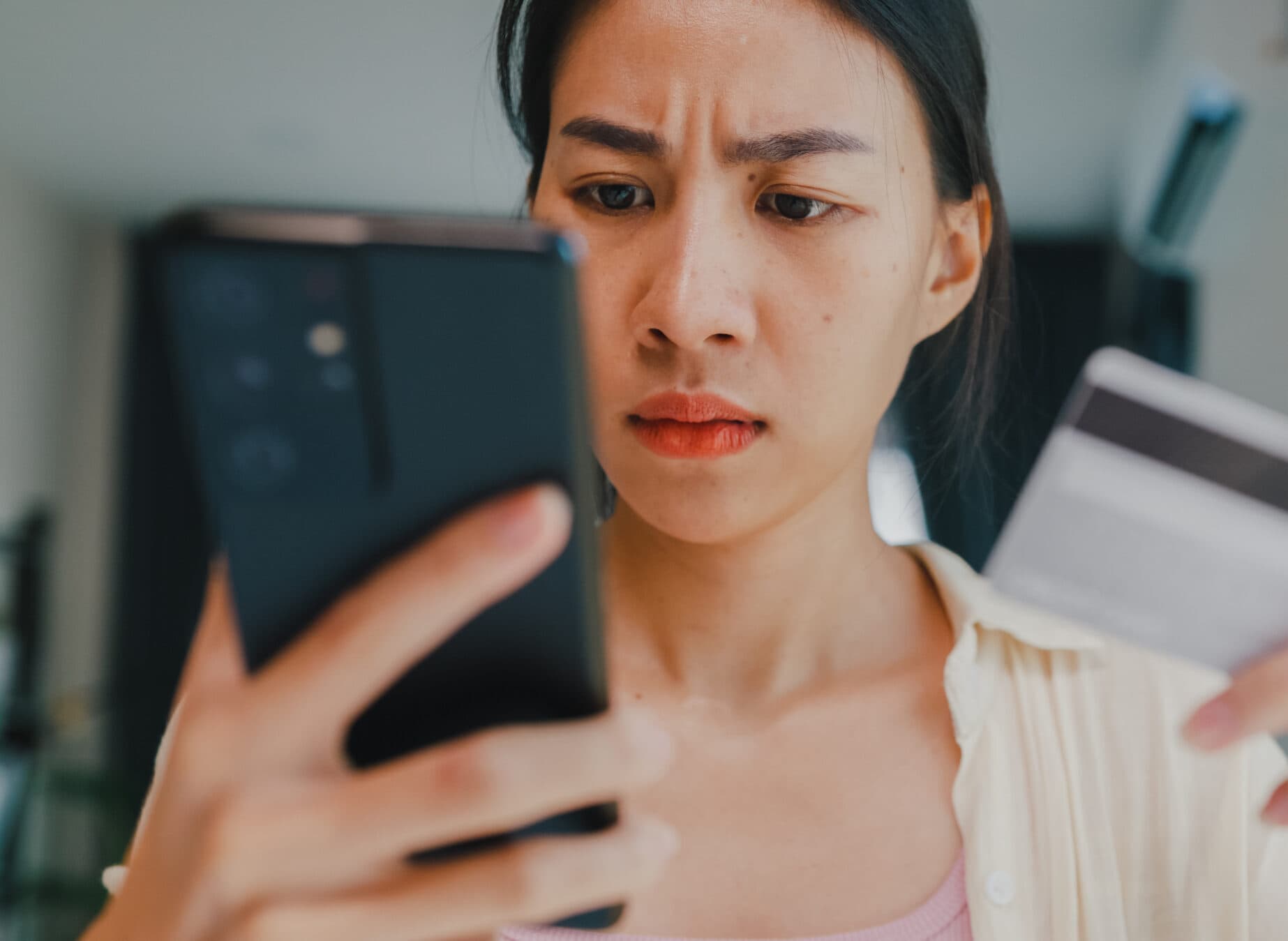 Personne effectuant un paiement en ligne avec une carte bancaire et un smartphone